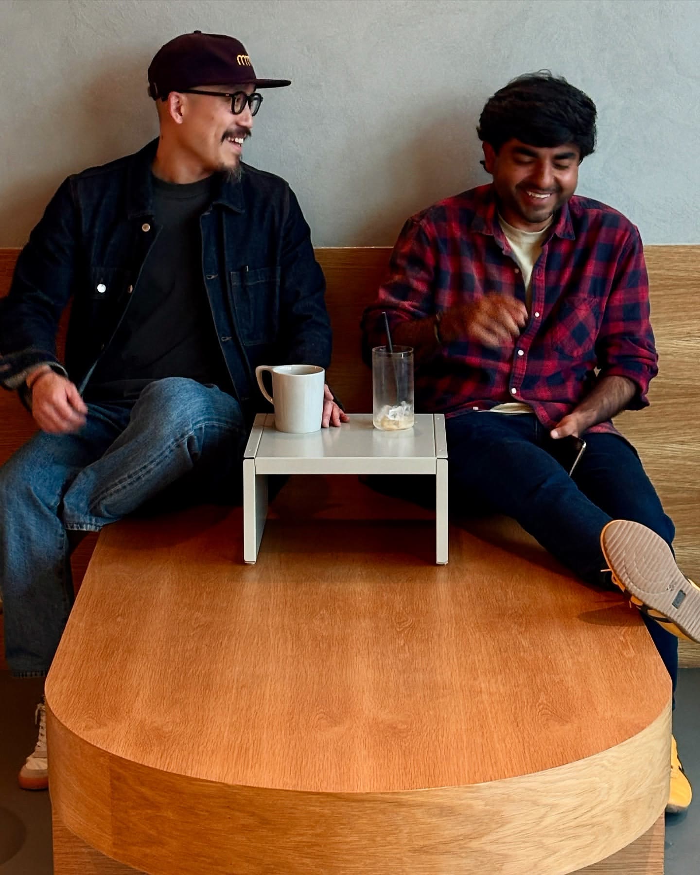 two regulars mid-laugh on the bench
